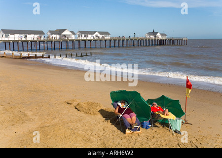 Due donne inglese brave l'inglese estate sole in sedie a sdraio sulla spiaggia con cielo blu in Southwold Suffolk REGNO UNITO Foto Stock