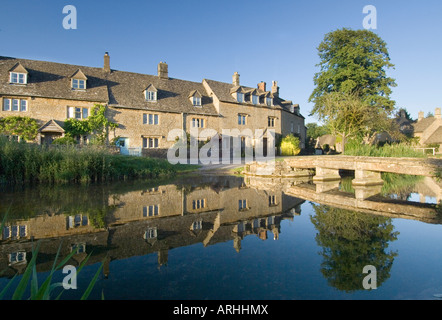 Una vista della tradizionale cotswold cottage nella luce della sera, che si riflette nel fiume occhio alla macellazione inferiore nel Gloucestershire, Regno Unito Foto Stock
