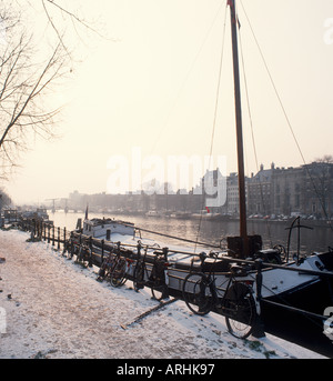 La mattina presto sulle rive del fiume Amstel guardando verso ponte Magere, Amsterdam, Paesi Bassi Foto Stock