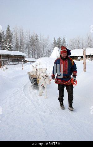 Uomo che indossa abiti tradizionali che portano le renne in Lapponia Finlandia settentrionale a nord del Circolo Polare Artico Foto Stock