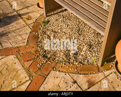 Un pavimento di ghiaia su un piccolo patio che mostra il rischio di fuoriuscita sulla pavimentazione [vedi immagine adiacente Foto Stock