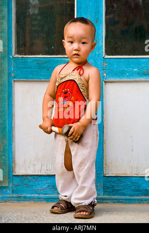 Giovani asiatici orientali cinese contadina boy in piedi con un martello in mano la Cina JMH3032 Foto Stock
