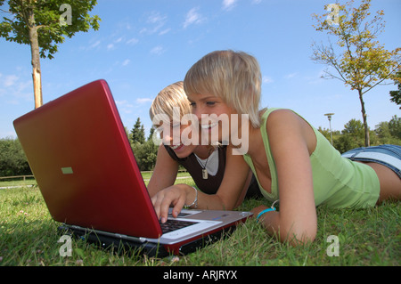 Junge Mädchen mit laptop auf wiese - giovani ragazze giacente in erba lavora con i notebook Foto Stock