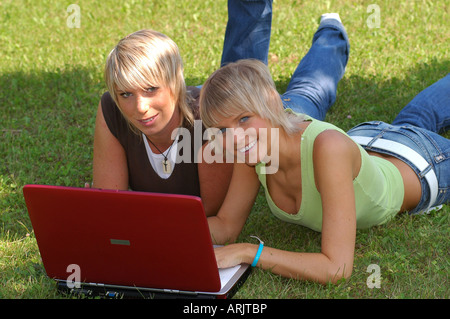 Junge Mädchen mit laptop auf wiese - giovani ragazze giacente in erba lavora con i notebook Foto Stock