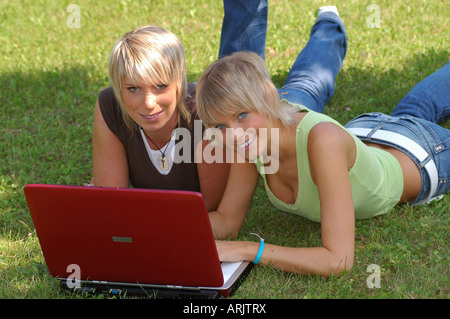 Junge Mädchen mit laptop auf wiese - giovani ragazze giacente in erba lavora con i notebook Foto Stock