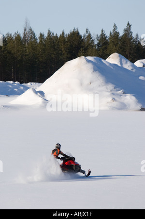 Giovane uomo alla guida di motoslitta in inverno , Finlandia Foto Stock