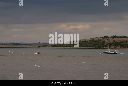 Barche ormeggiate in Swale nell'estuario del Tamigi su una burrascosa serata Osono Faversham Kent REGNO UNITO 10 Agosto 2006 Foto Stock