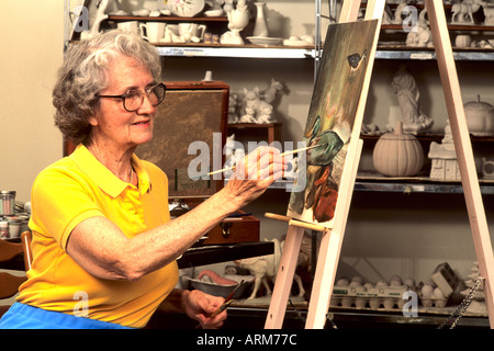 Pensionati anziani donna artisti gode di creazione di un dipinto ad olio Foto Stock