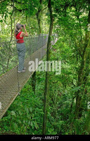 Un visitatore su un ponte sospeso su Arenal ponti pensili Trail Arenal Costa Rica Foto Stock