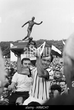 Il calcio tedesco campionato amatoriale 1969, finale, SC Juelich 1910 versus SpVgg Erkenschwick 2:1, Grotenburg Stadium di Krefeld-Uerdingen, giocatori di calcio e gli appassionati di calcio di SC Juelich contentezza per la vittoria del titolo, capitano della squadra Heinz Hoss presenta la cu Foto Stock