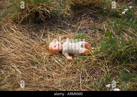 Abbandonato childs bambola tra l'erba Foto Stock