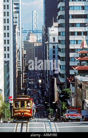 Funivia fino a cavallo California Street nel centro cittadino di San Francisco con Oakland Bay Bridge Foto Stock