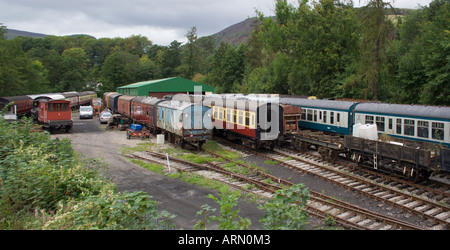 Una raccolta di vecchie vintage vetture e carri ferroviari in schierata in attesa di essere ripristinata. Il Galles. Regno Unito. Foto Stock