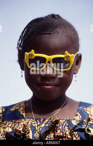 Niamey, Niger, Africa occidentale. Nigerien Ragazza con nuovi occhiali e abiti per Eid al-Fitr. Foto Stock