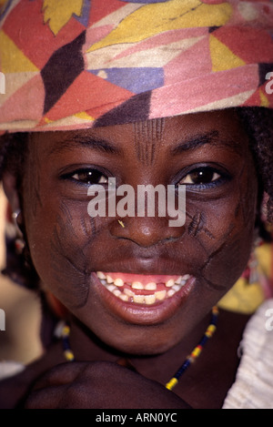Maraka, Niger, Africa occidentale. Hausa Ragazza con scarificazione del viso per indicare appartenenza tribale. Un pezzo di paglia detiene il posto per un naso pin. Foto Stock