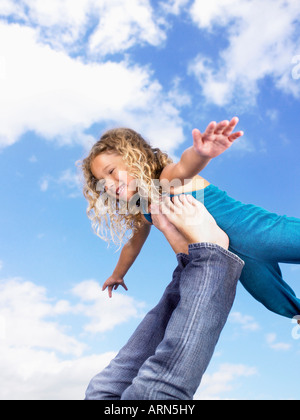 Ragazza giovane rotearlo piedi in aria Foto Stock