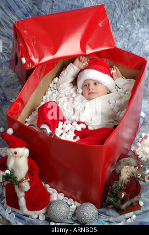Piccolo Ragazzo nella casella avvolto come vacanze di Natale presente Foto Stock
