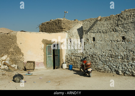 Ciclomotore davanti a una casa tipica al vecchio villaggio di Qurna West Bank Luxor Valle del Nilo in Egitto Foto Stock