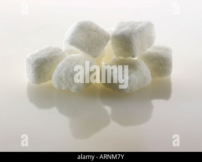 I cubetti di zucchero bianco tagliati grossolani continuano a vivere contro un bianco sfondo Foto Stock