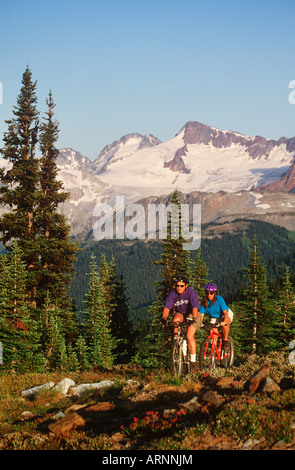 Coppia giovane correre in bici in area alpina, Whistler, British Columbia, Canada. Foto Stock