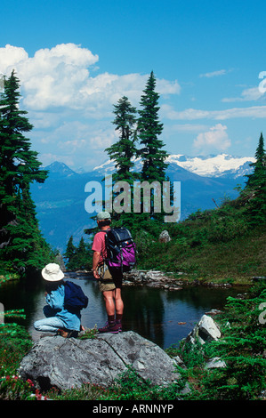 Giovane passeggiate nel prato alpino sulla cima di Whistler, Whistler, British Columbia, Canada. Foto Stock