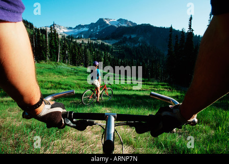 La donna vede attraverso il manubrio di partner Bike Whistler, British Columbia, Canada. Foto Stock