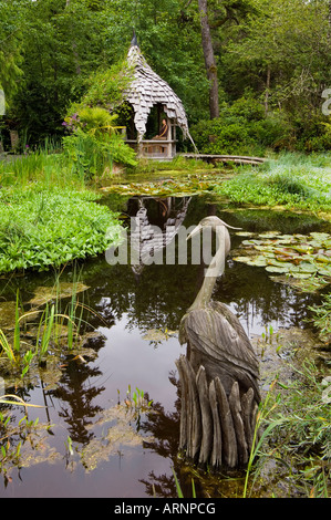 Tofino Giardini Botanici lily pond con la scultura in legno, l'isola di Vancouver, British Columbia, Canada. Foto Stock