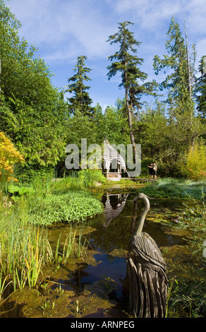 Tofino Giardini Botanici lily pond con la scultura in legno, l'isola di Vancouver, British Columbia, Canada. Foto Stock