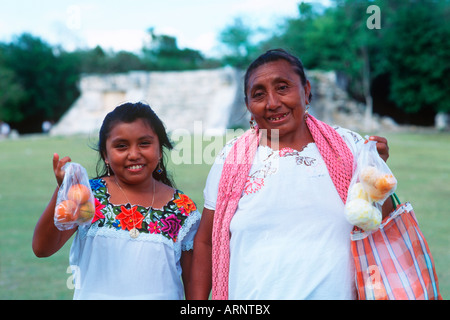 Il Messico e la penisola dello Yucatan a Chichen Itza, locale maya di donna e bambina vendita arance Foto Stock