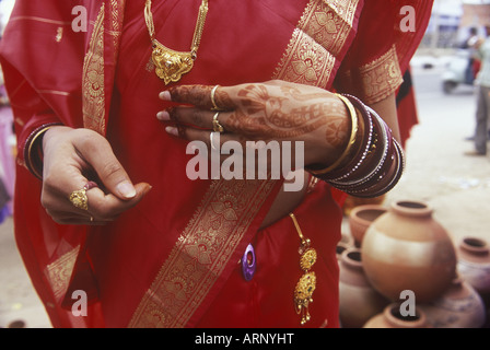 India, Rajsatan, Jaipur donna di mano con henna tattoo, sari rosso e oro Gioielli Foto Stock