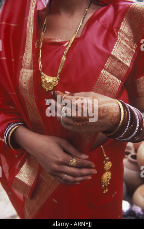 India, Rajsatan, Jaipur donna di mano con henna tattoo, sari rosso e oro Gioielli Foto Stock