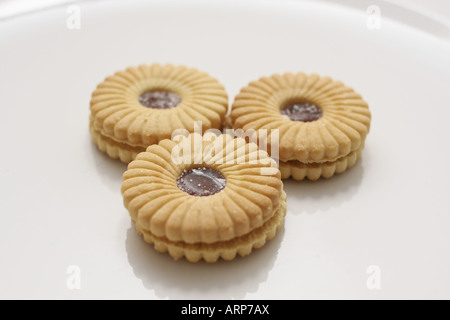 Tre Sandwich di marmellata i biscotti su una piastra bianca Foto Stock