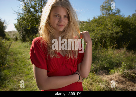 Giovane donna in natura indossando abito rosso Foto Stock