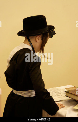 Israele Bnei Brak sinagoga della congregazione Premishlan su Purim holiday un ragazzo lettura il Sidur Libro di preghiera Foto Stock