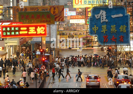 HONG KONG, Luglio 2007 pedoni attraversare la strada sotto la pioggia a Causeway Bay Hong Kong Foto Stock