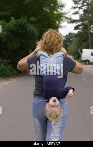 Bambino portato a testa in giù Foto Stock