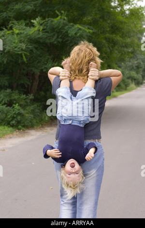 Bambino portato a testa in giù Foto Stock