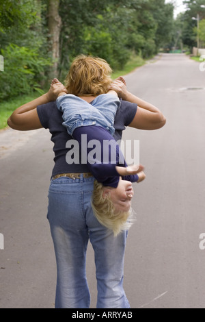 Bambino portato a testa in giù Foto Stock