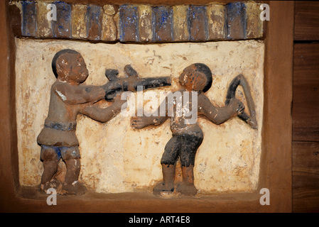 Abomey Benin Palastskulpturen von Abomey restauriert vom Getty Conservation Institute Basrelief im Palast vom Koenig Glele Ein Krieger zielt direkt auf den Kopf eines feindlichen Yaruha Abomey Palazzo Benin sculture di Abomey restaurate dal Getty Conservation Institute bassorilievo Bas nel palazzo di Re Glele Un guerriero mira puntato alla testa di Yaruha di Un nemico Yaruha Foto Stock