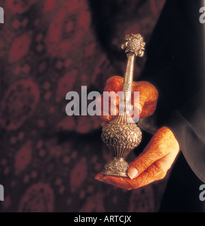 La donna araba con henna-verniciato mani sprinkler rosewater (aggiunto a dolci e utilizzato come corpo profumo) Foto Stock