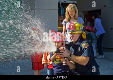 Una scuola elementare boy diventa una possibilità di spruzzare una manichetta antincendio Foto Stock