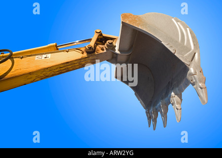 Benna di un escavatore in piedi contro il cielo blu. Godet de pelleteuse sur fond de ciel bleu. Foto Stock