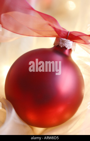 Red ornamento di Natale contro un sfondo setosa che è diffusa dolcemente Foto Stock