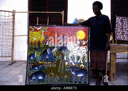 Un bottegaio che mostra un acrilico dipinto da un artista locale in Stone Town Zanzibar Tanzania Africa orientale Foto Stock