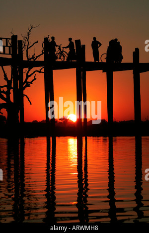 Popolo birmano attraversando U Bein's Bridge al tramonto , Amarapura, vicino a Mandalay, Birmania (Myanmar) Foto Stock