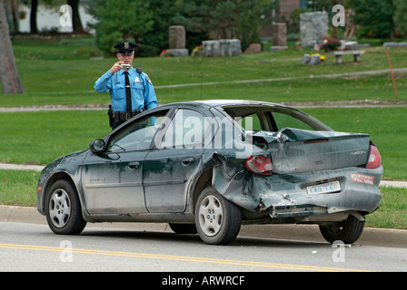 Incidente automobilistico ferisce una donna mentre la polizia partecipare al relitto chiamando un carro attrezzi per rimuovere la vettura Foto Stock