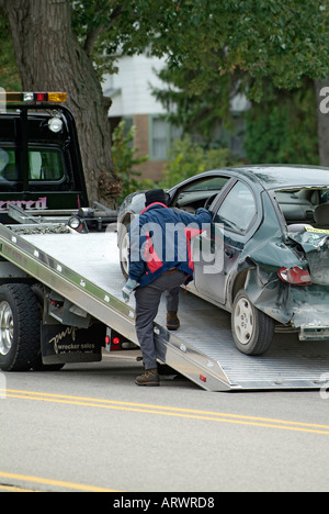 Incidente automobilistico ferisce una donna mentre la polizia partecipare al relitto chiamando un carro attrezzi per rimuovere la vettura Foto Stock