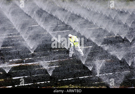 Un impianto di trattamento delle acque reflue operatore effettua la pulizia essenziale e lavori di manutenzione Foto Stock