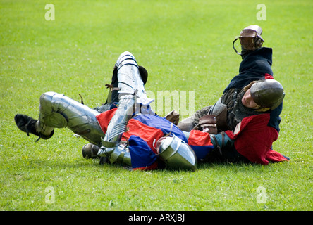 Due cavalieri in armatura combattimenti di mano in mano rotolando sul pavimento del campo di battaglia Renactment storica battaglia di Tewkesbury Inghilterra Foto Stock