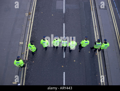 Sottile linea blu poliziotti in linea alla ricerca di prove e indizi per il crimine commesso in City of London Street Foto Stock